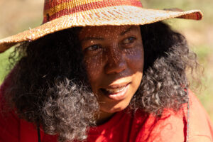 A photo of founder Shatae Johnson wearing a straw hat and red shirt.